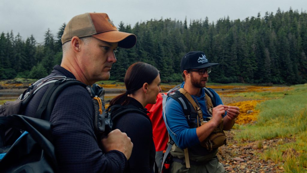 Guide Mattheus Temple at Waterfall Creek on Chichagof Island explaining intertidal foods and bear foraging behavior to guests.