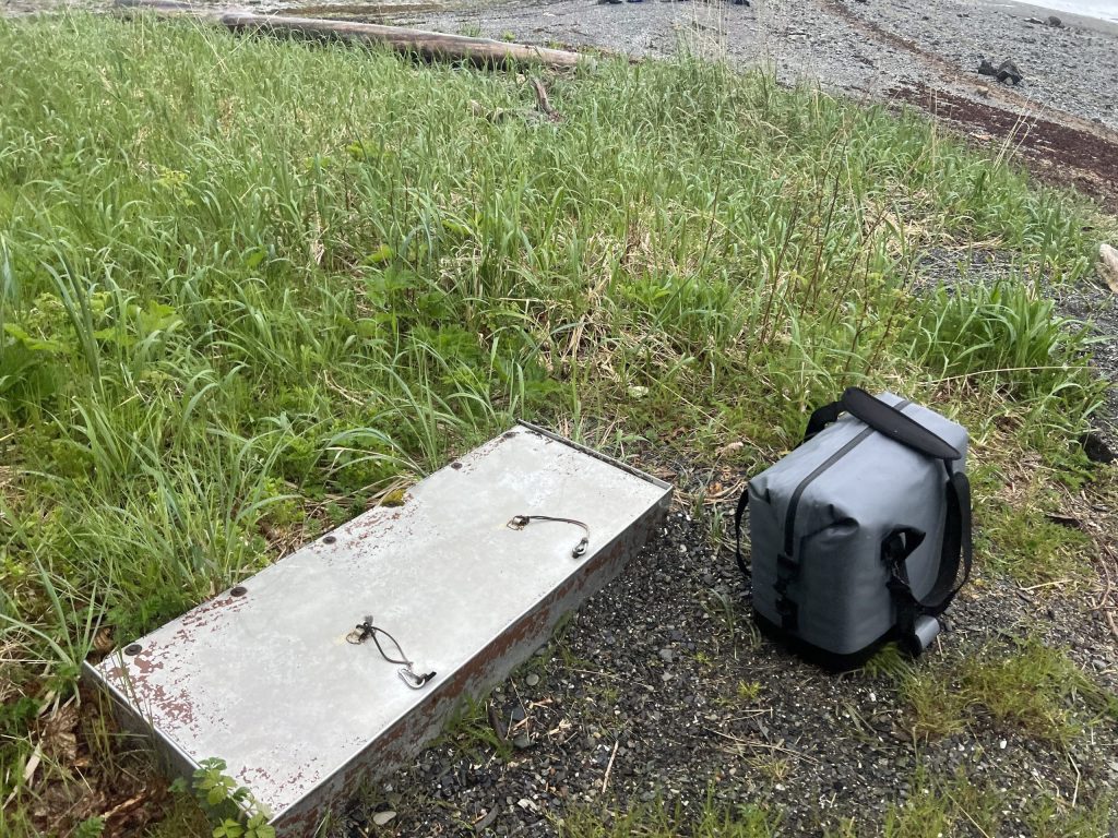 USFS buried metal food locker at Pack Creek with Wild Coast Excursions’ packed lunch bag stored properly in the designated food area.